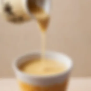 Creamy condensed milk drizzling into tea mixture